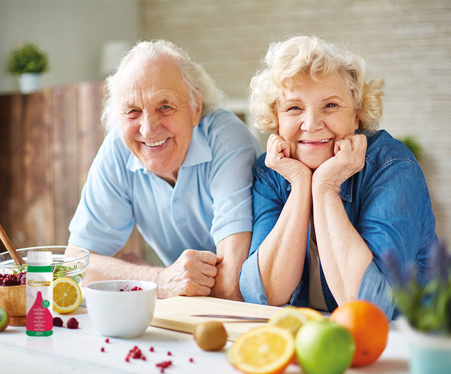 aelteres Paar laechelnd in der Kueche